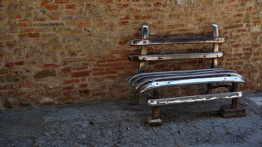 Repurposed Car Bumper Bench Against Weathered Brick Wall