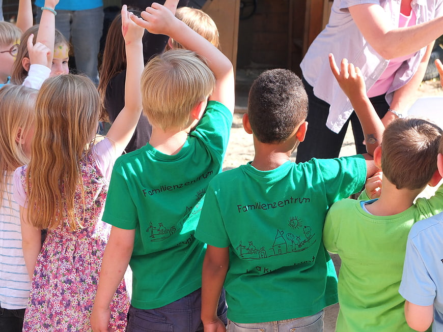 Children raising hands at outdoor family center event