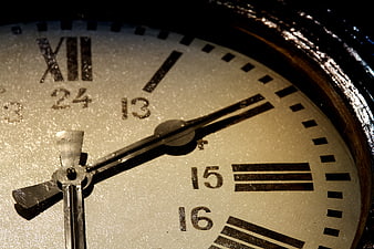 Close-up of vintage clock face with roman numerals and 24-hour markings