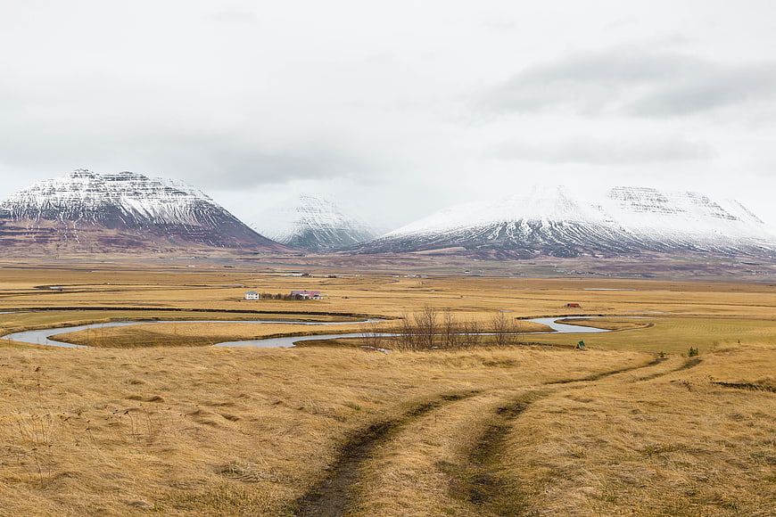 Snow-Capped Mountains Over Golden Highland Valley with Winding River