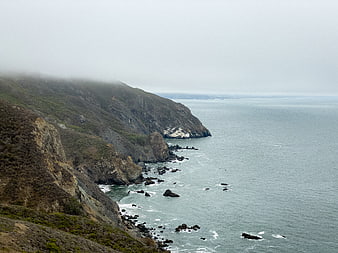 Misty Rocky Coastline with Ocean Waves and Foggy Cliffs