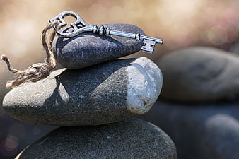 Vintage Key on Balanced Stones with Bokeh Background
