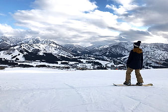 Snowboarder Looking at Snowy Mountain Range