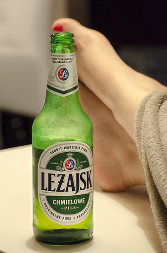 Cold Lezajsk beer bottle with relaxed foot in background