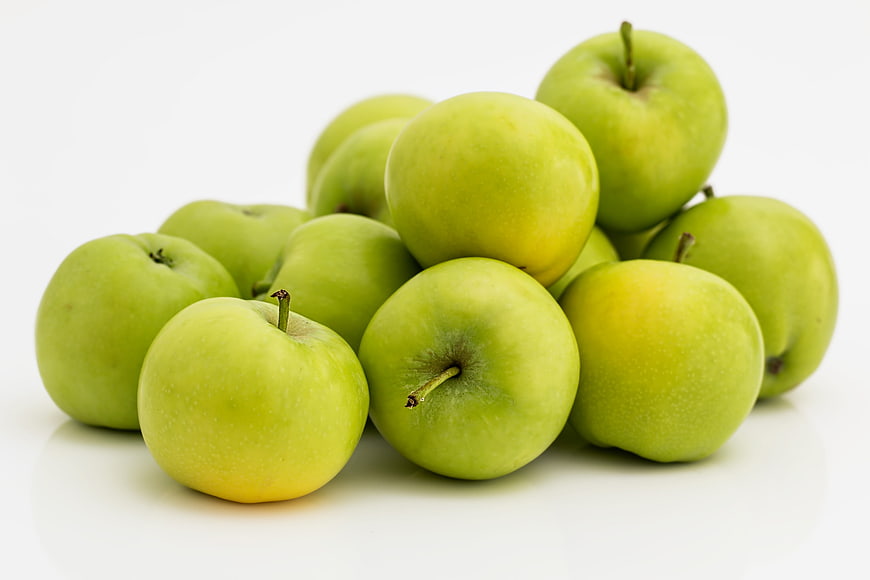 Fresh Green Apples Piled on White Background