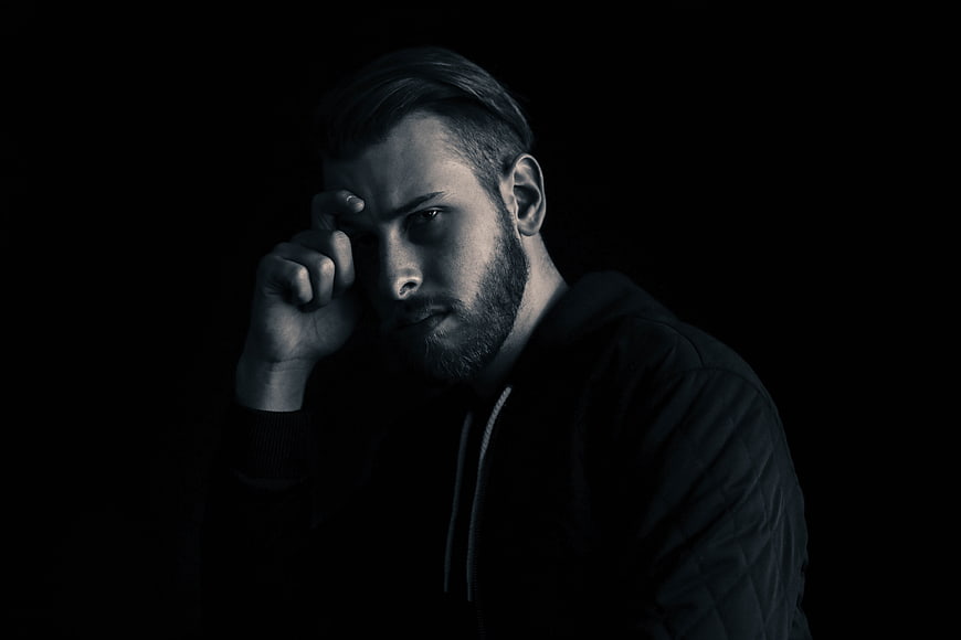Moody Portrait of Pensive Man in Dark Hoodie
