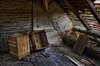Abandoned attic interior with wooden crates and decaying roof beams