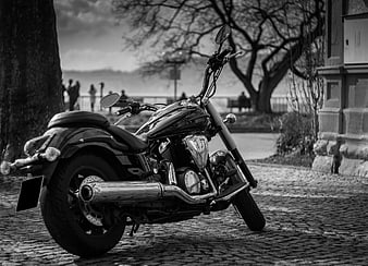 Black and white motorcycle parked on cobblestone street