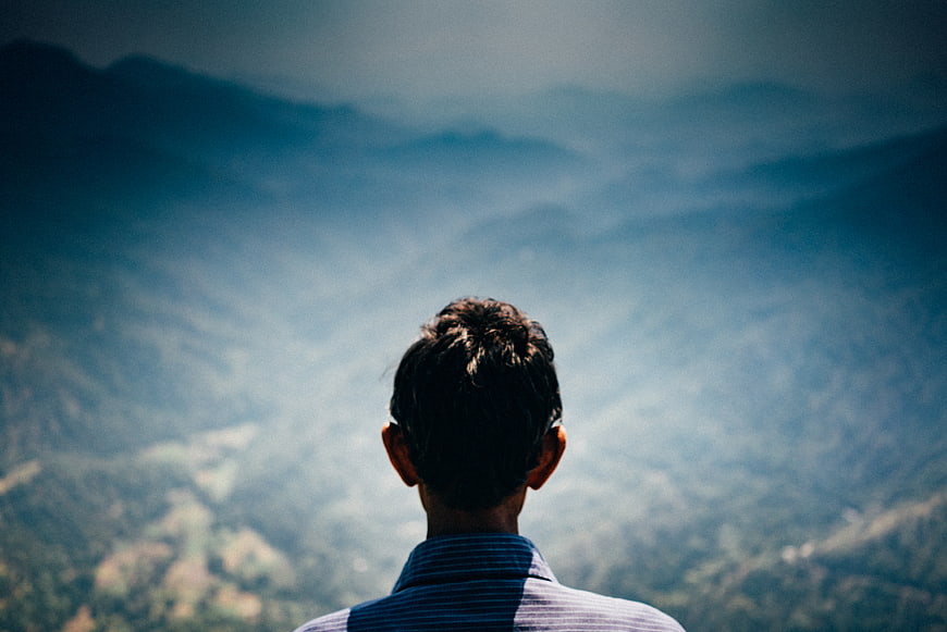 Man Looking at Misty Mountain Landscape from Behind
