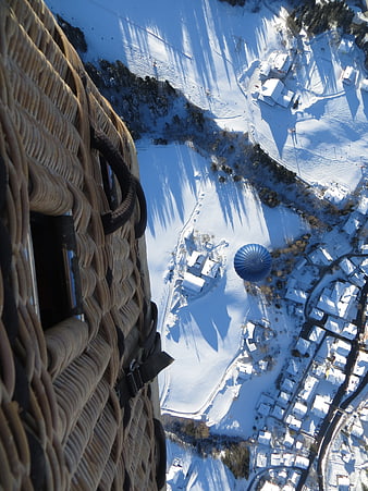 Aerial view from hot air balloon basket over snowy village