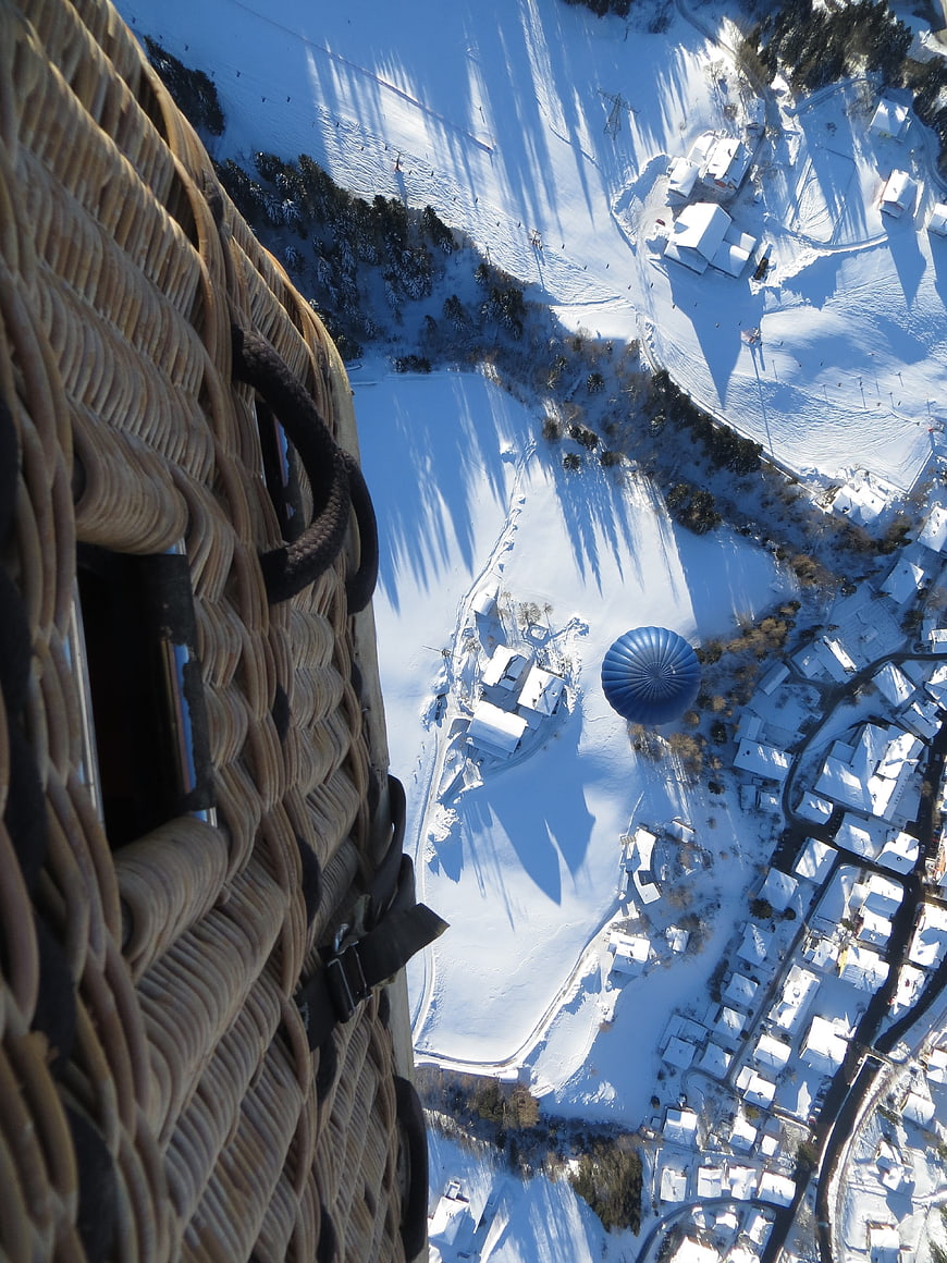 Aerial view from hot air balloon basket over snowy village