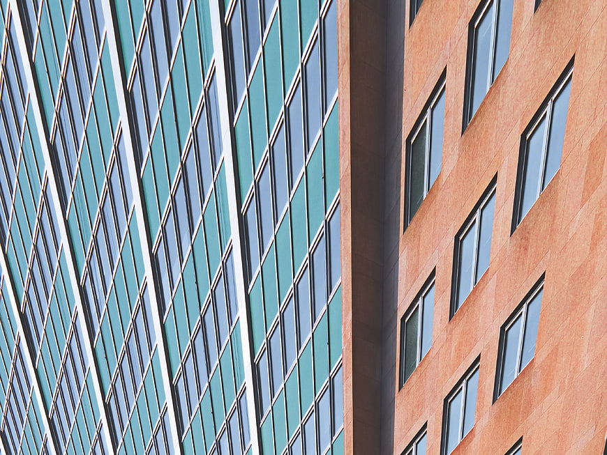 Abstract modern architecture with teal glass and orange facade