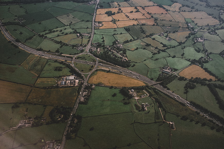 Aerial View of Rural Highway Intersection and Patchwork Fields