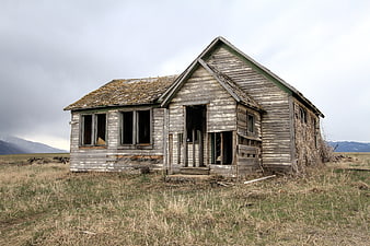 Abandoned Weathered Wooden Farmhouse in Rural Landscape