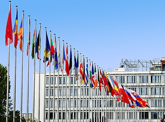 Row of International Flags in Front of European Parliament Building