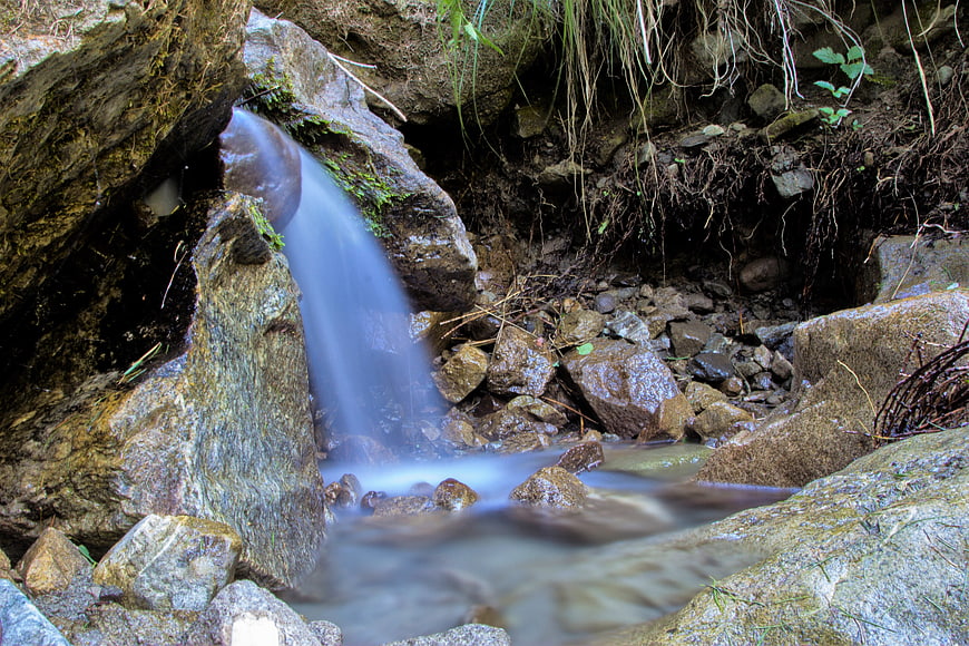 Small waterfall cascading over rocks in a forest stream