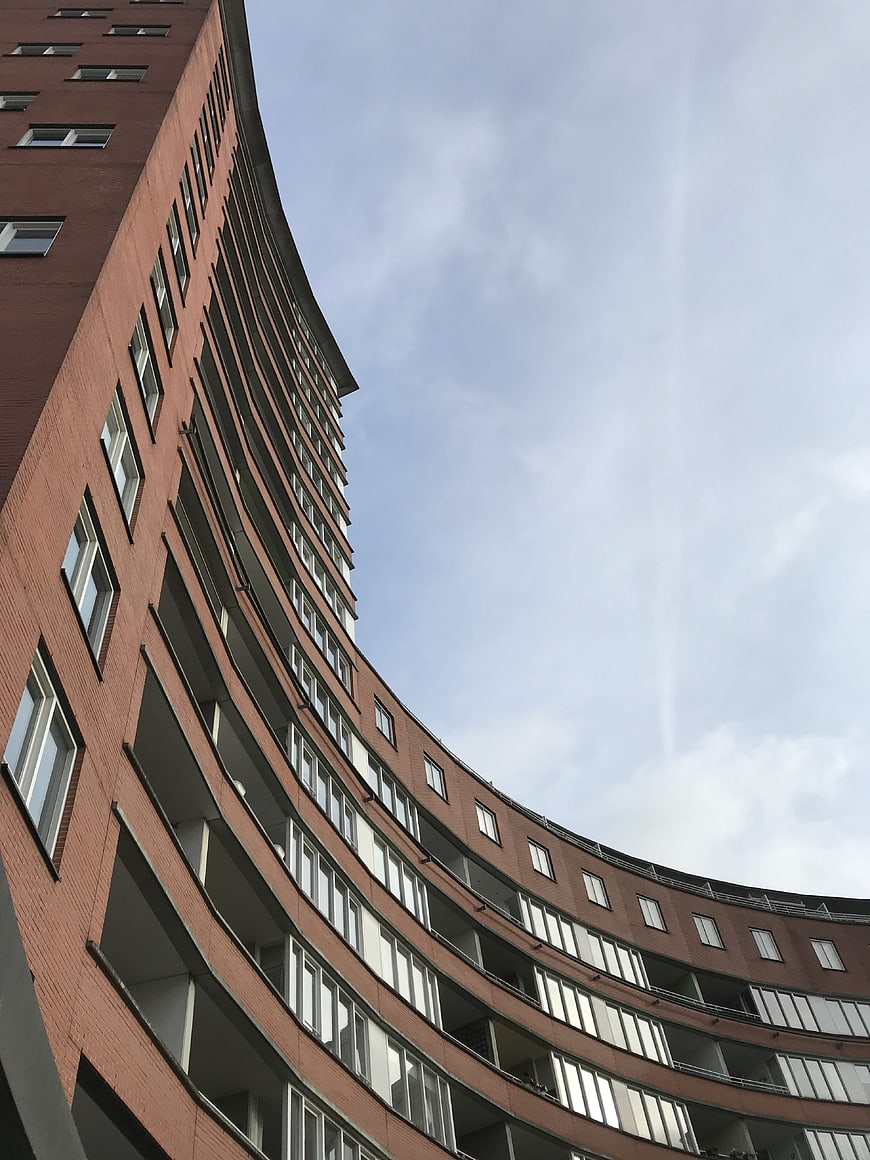 Low angle view of curved modern brick office building