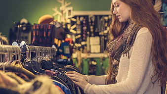 Young woman browsing clothes in a vintage boutique