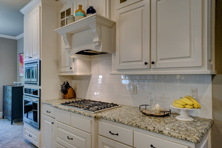 Modern white kitchen with granite countertops and gas stove