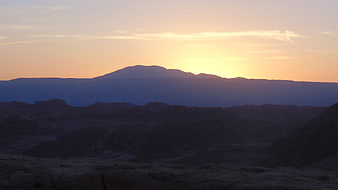 Silhouette of mountain range at sunset in desert landscape