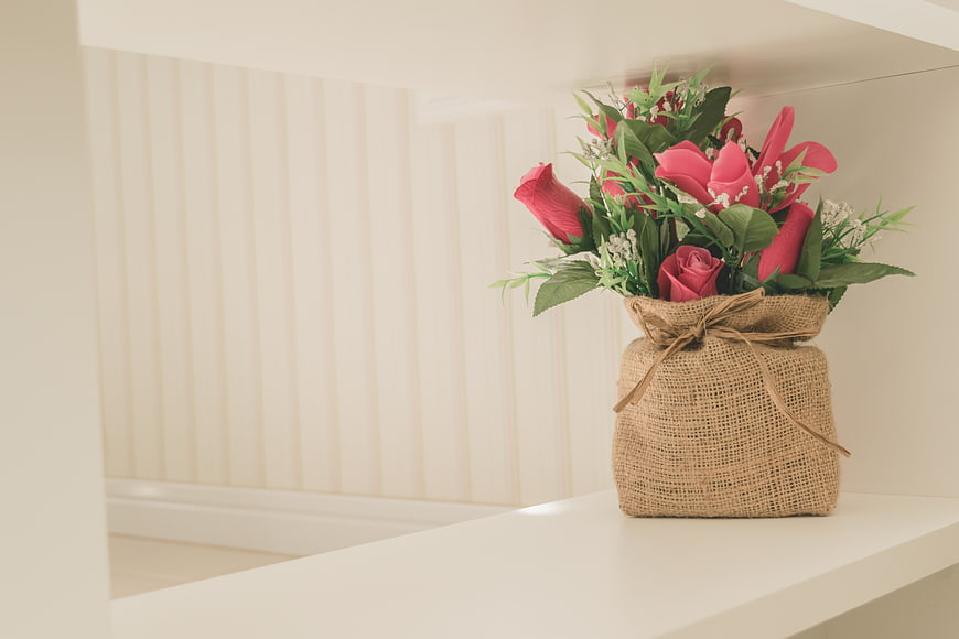 Pink Roses in Burlap Wrapped Vase on White Shelf