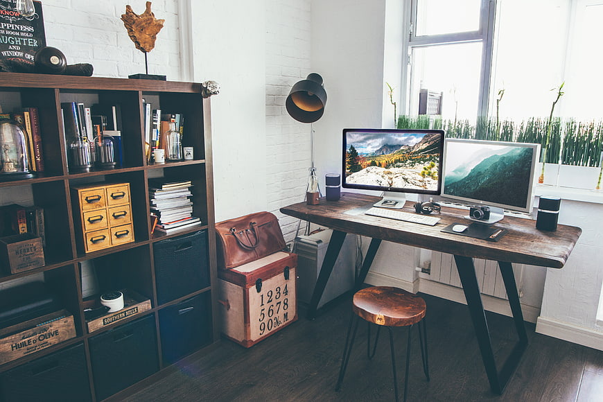 Modern Home Office Workspace with Dual Monitors and Bookshelf