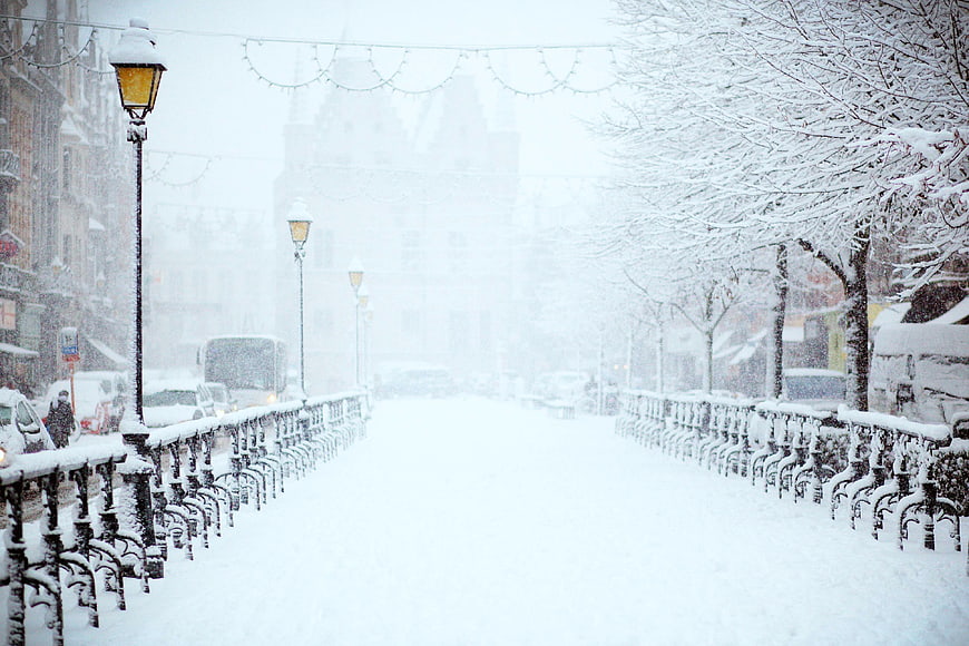 Snowy City Street with Vintage Lamp Posts and Railing