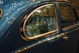 Close-up of vintage blue car window and steering wheel