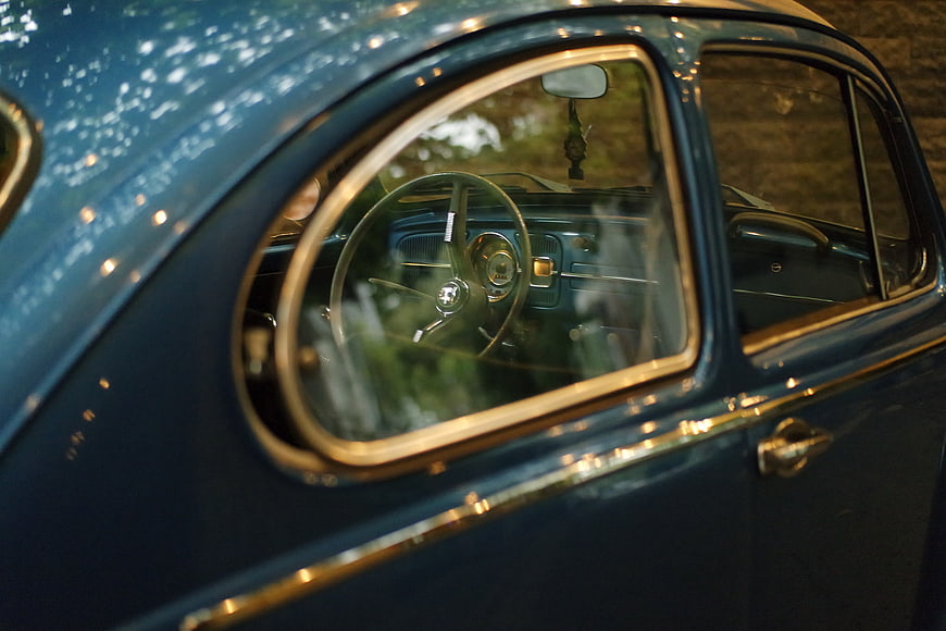Close-up of vintage blue car window and steering wheel