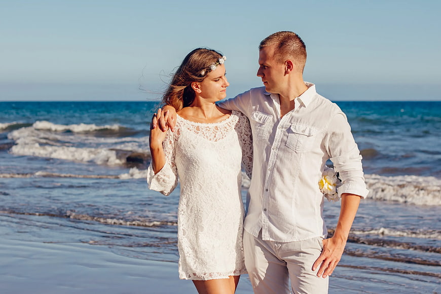 Romantic Couple in White on Beach at Sunset
