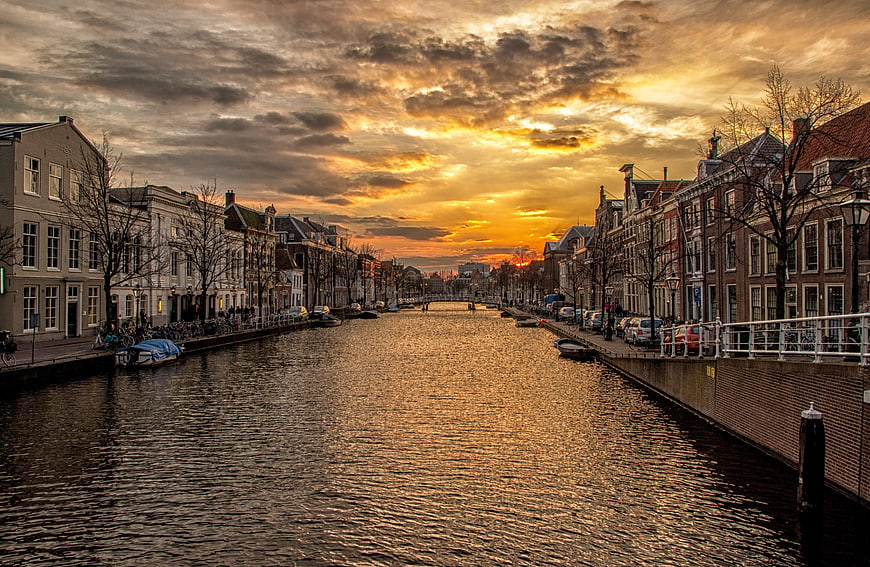 Dramatic Sunset Over Amsterdam Canal with Traditional Dutch Architecture