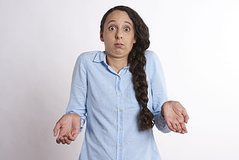 Confused woman shrugging with hands up against white background
