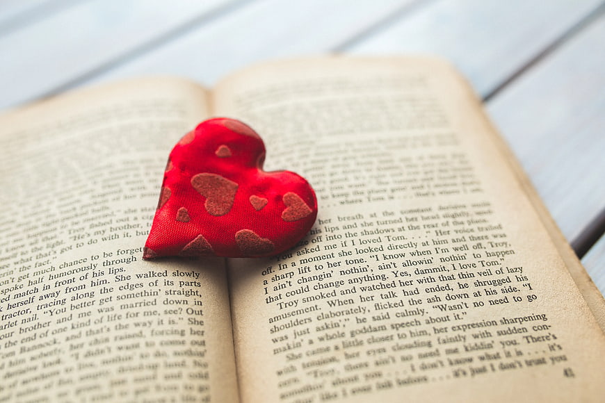 Red fabric heart on open book pages
