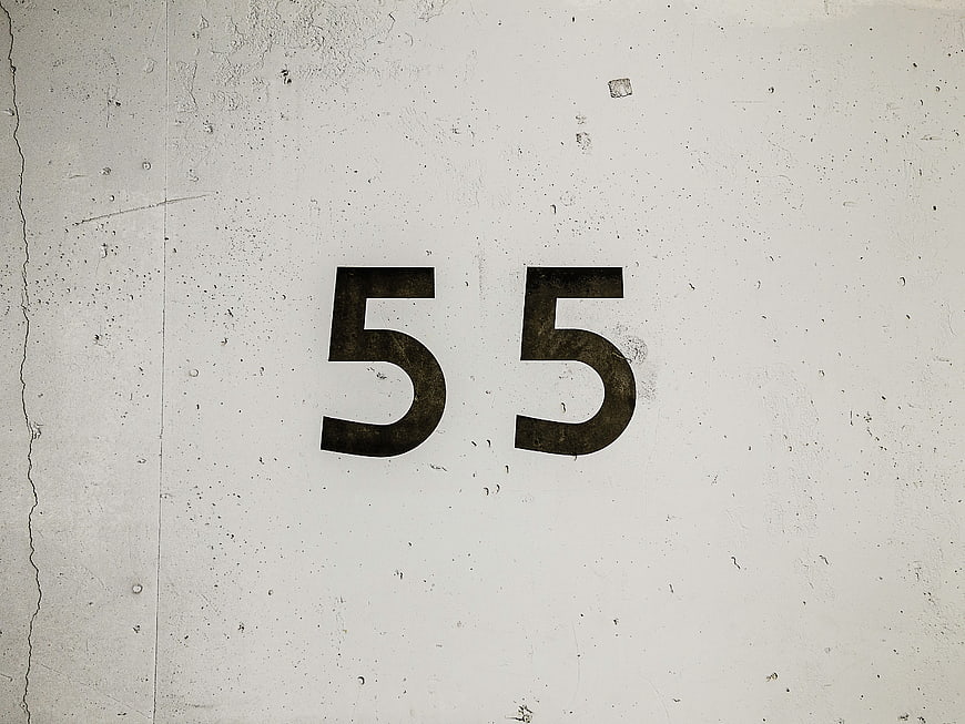 Number 55 on textured concrete wall background
