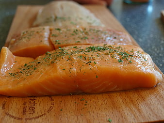 Raw Salmon Fillets Seasoned With Herbs On Wooden Cutting Board