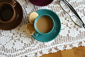 Top View of Coffee Cup, Biscuits, and Glasses on Lace Doily