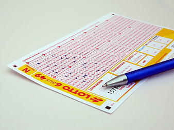 German Lotto 6aus49 Ticket With Blue Ballpoint Pen On White Surface