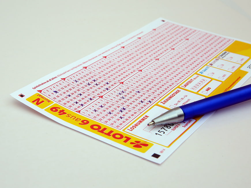 German Lotto 6aus49 Ticket With Blue Ballpoint Pen On White Surface