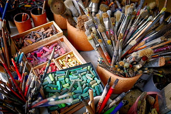 Colorful Art Supplies and Paint Brushes in Wooden Containers