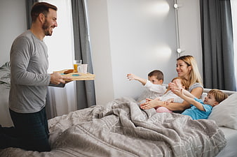 Happy family enjoying breakfast in bed together