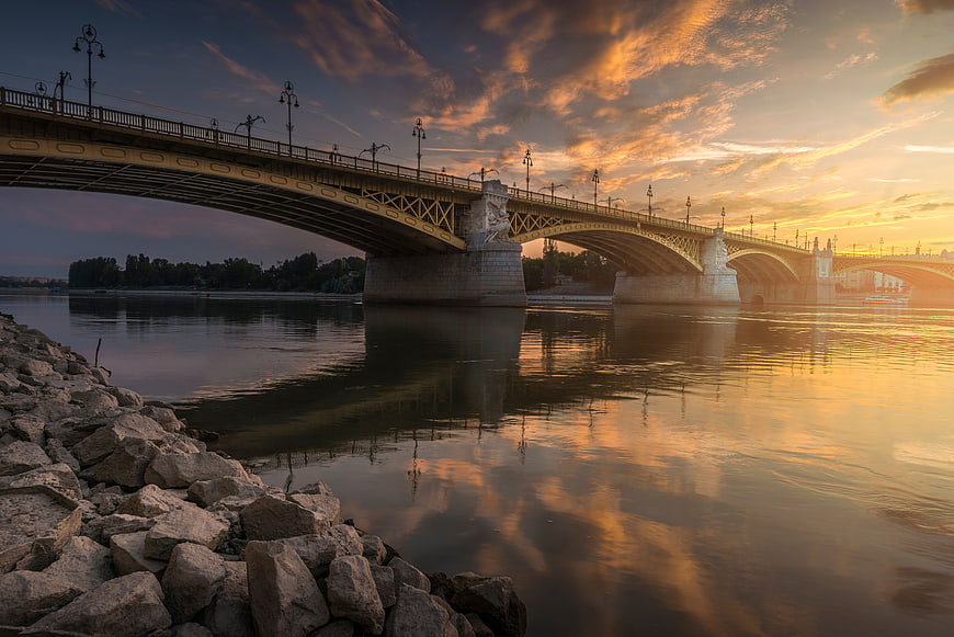 Golden Sunset Over Arched Bridge with River Reflections