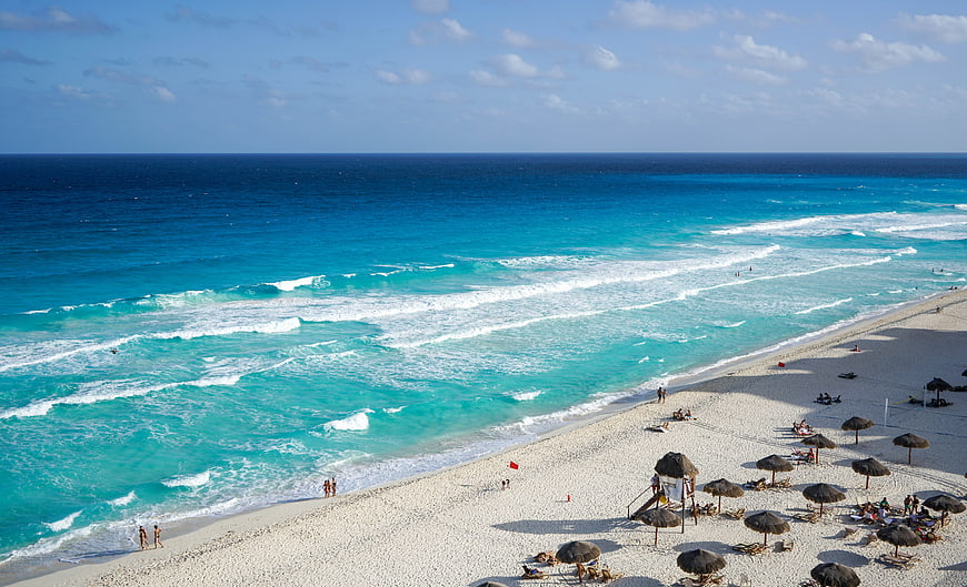 Aerial View of Turquoise Caribbean Beach with Palm Umbrellas