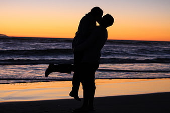 Silhouette of Couple Kissing on Beach at Sunset