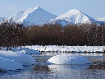 Snow-covered mountains and river in winter landscape