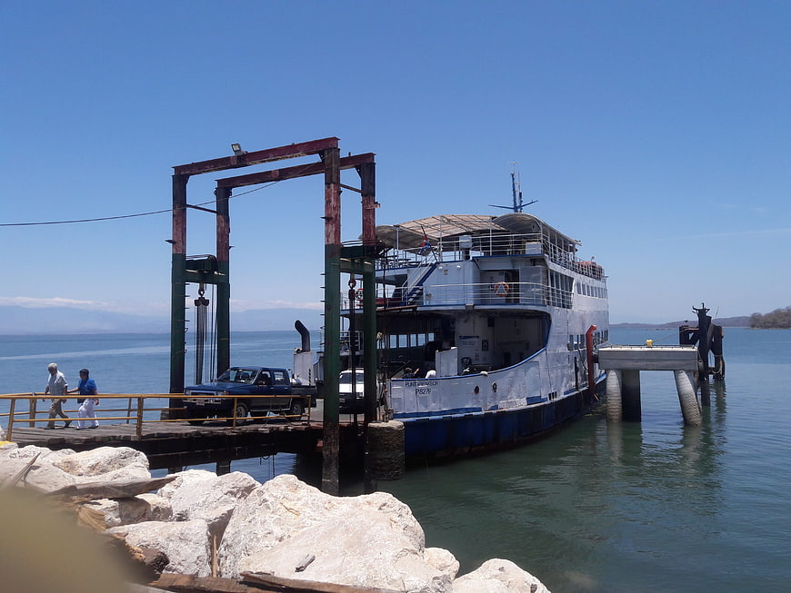 Ferry boat docking at pier with car and passengers