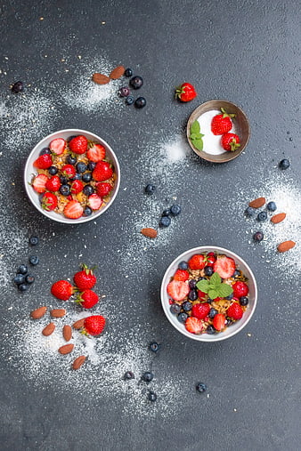 Overhead view of healthy breakfast bowls with berries and granola