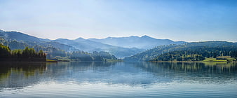 Panoramic View of Serene Lake with Misty Mountains