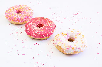 Three Glazed Donuts with Sprinkles on White Background