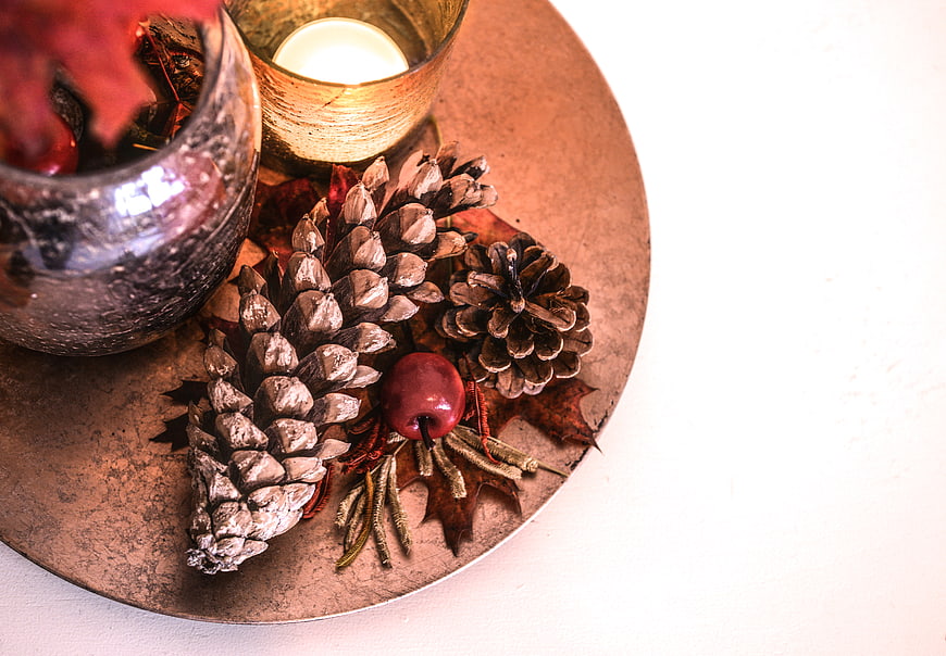 Autumn centerpiece with pinecones, candle, and copper tray