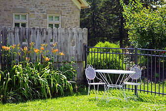 White Patio Furniture in Sunny Garden with Flowers